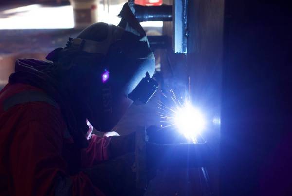 Picture of a welder in low light, welding.